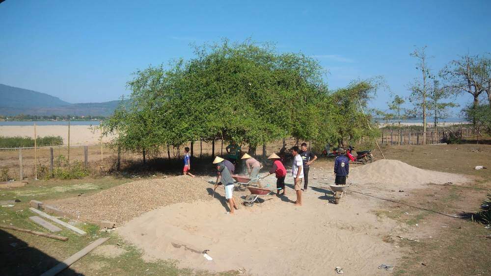 Villagers working with sand, gravel and wheelbarrows during the Ban Bangxay school renovation.